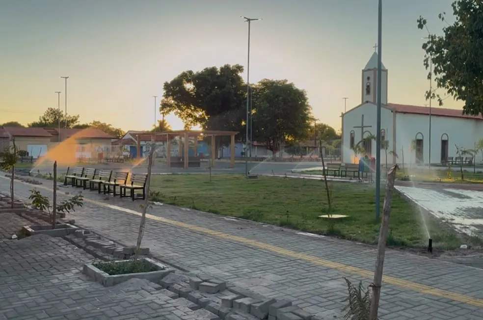 Aspersores irrigando o gramado da praça em Hugo Napoleão
